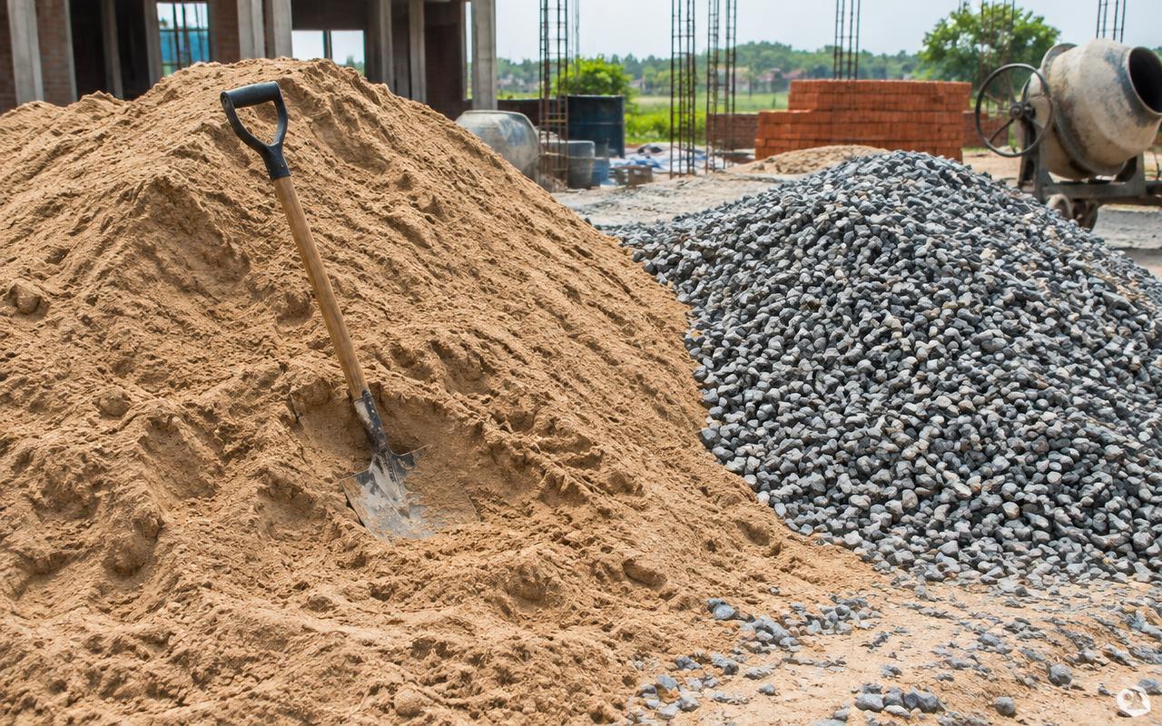 Sand and crushed aggregate stockpiles at a construction site