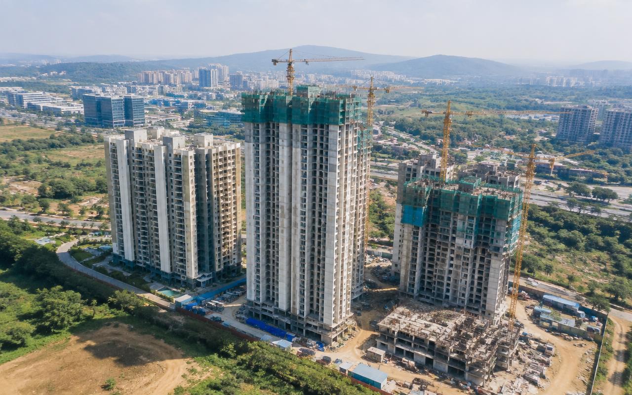 Aerial view of residential towers rising with cranes in Hinjewadi, Pune